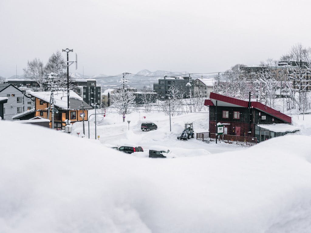 A serene winter scene in snowy Niseko, Hokkaido, showcasing a tranquil village covered in snow.